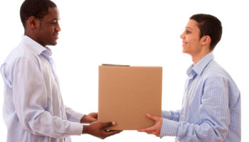 Two people holding a box in front of each other.